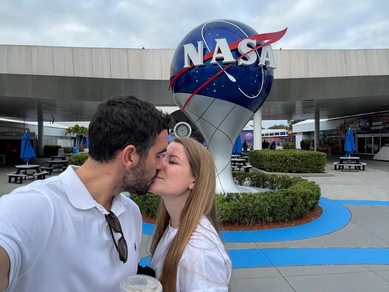 Beso frente al logotipo de la NASA