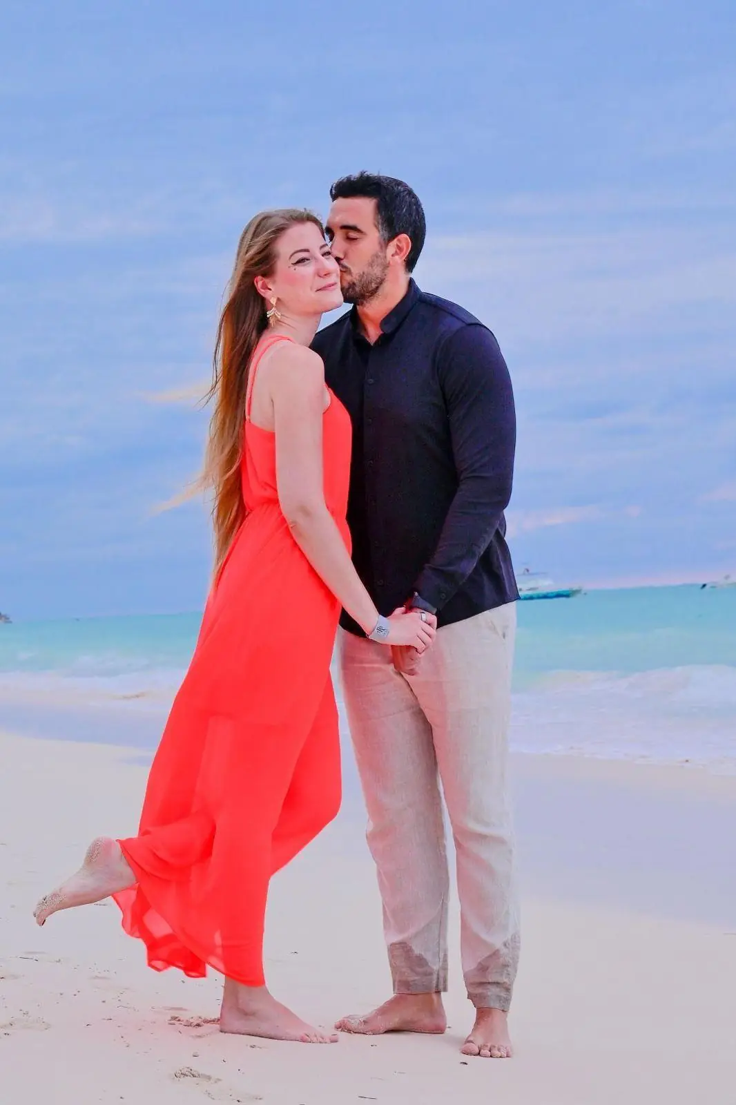 En la playa, con vestido coral
